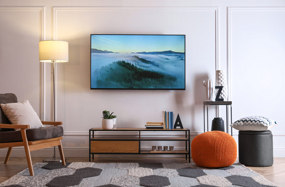 Light wooden panel behind the TV providing a bright and airy backdrop.