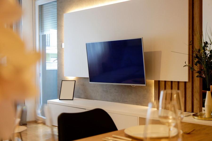 Smooth white panelling with subtle slat details behind the TV.